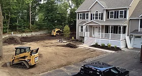 Skid-steer re-grading a yard to create swales in Orange Park